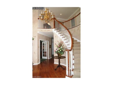 The two story foyer has hardwood flooring, a curve