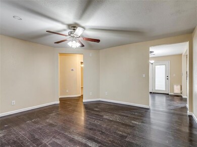 Unfurnished room featuring dark hardwood / wood-style flooring, ceiling fan, and a textured ceiling