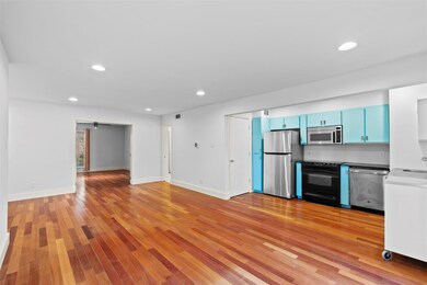 Kitchen with blue cabinetry, light hardwood / wood