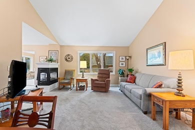 Living room with a 3-sided fireplace between the dining room