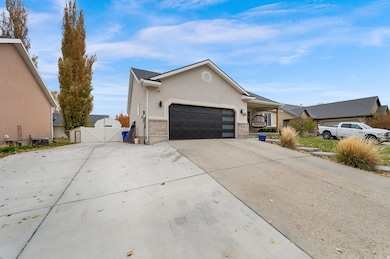 Single story home featuring concrete driveway, a gate, stucco siding, and an attached garage