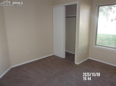 Unfurnished bedroom featuring dark carpet and a closet