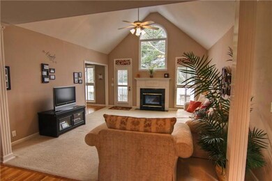 This open living room has a vaulted ceiling , fireplace and tons of natural light.
