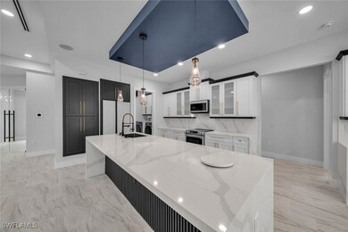 Kitchen with baseboards, light stone counters, sta