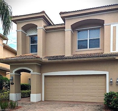 Mediterranean / spanish-style house featuring a tile roof, decorative driveway, stucco siding, and an attached garage