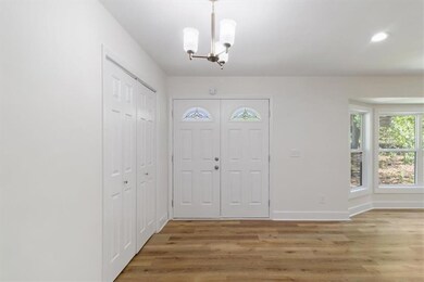 Foyer with baseboards, recessed lighting, light wo