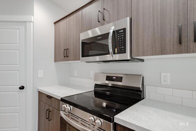 Kitchen with stainless steel appliances, light countertops, modern cabinets, and brown cabinets