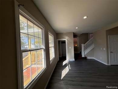 Foyer featuring recessed lighting, dark wood finished floors, and stairs