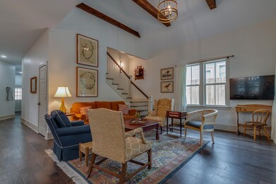 Living room featuring beam ceiling, stairway, wood