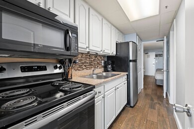 Kitchen with backsplash, white cabinets, a sink, a