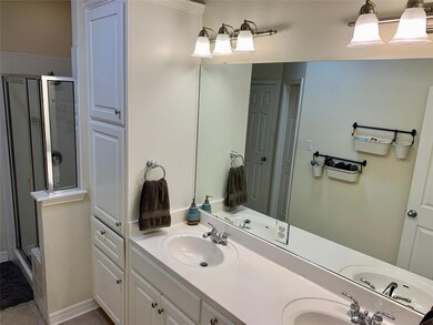 Full bath with a shower stall, double vanity, and