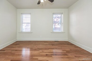 Spare room featuring dark wood finished floors and a ceiling fan