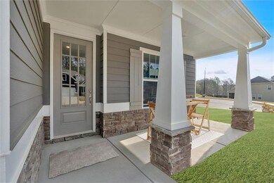 Doorway to property with a porch, stone siding, and a lawn