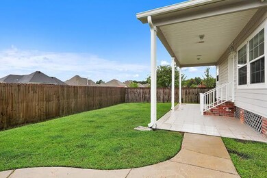 View of fenced back yard with a covered tiled pati