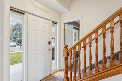 Foyer entrance with stairway and light wood-style floors