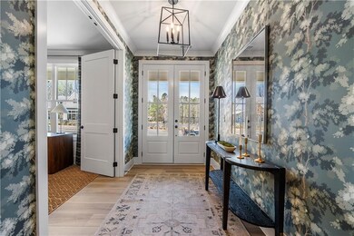 Foyer entrance with wallpapered walls, french door
