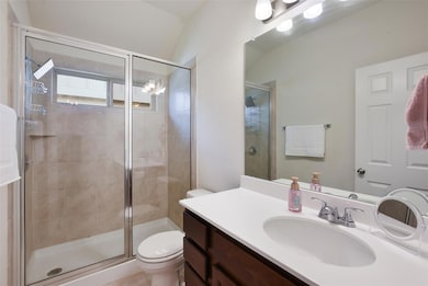 Full bathroom with toilet, vanity, and a shower s