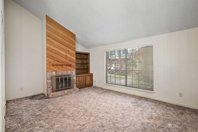 Spacious family room with woodburning fireplace and built-in cabinet.