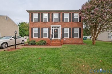 Colonial inspired home featuring brick siding and a front lawn