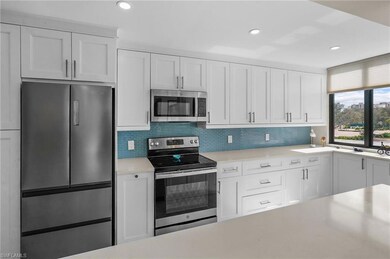 Kitchen with appliances with stainless steel finishes, white cabinetry, recessed lighting, backsplash, and light stone counters