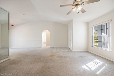 Carpeted empty room with vaulted ceiling and ceili