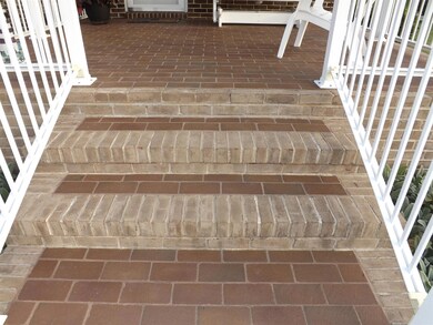 Wide steps, with custom brick pavers, lead to the covered back porch.