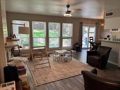 Living room featuring dark wood-type flooring, a ceiling fan, and a textured ceiling