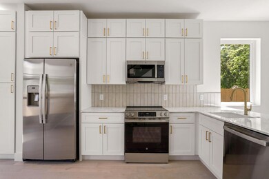Kitchen featuring white cabinetry, light stone co