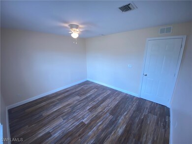 Unfurnished room with a ceiling fan, dark wood fin