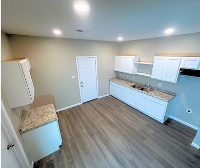 Kitchen with white cabinets, dark wood-style floors, and recessed lighting