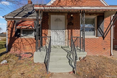View of front facade featuring brick siding, covered porch, and a chimney