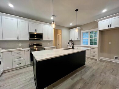 Kitchen with white cabinetry, light hardwood / woo