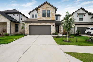 View of front of home featuring a garage, stone s