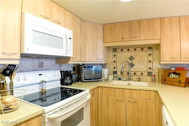 Kitchen with white appliances, decorative backspla