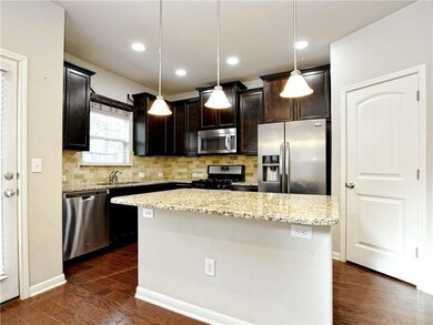 Kitchen featuring dark wood-style floors, light s