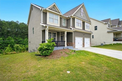 Craftsman-style house featuring a porch, board and batten siding, an attached garage, driveway, and a front yard