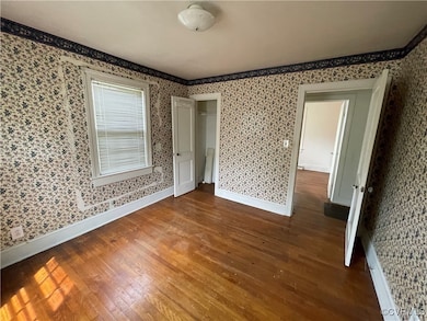 Empty room with wood finished floors, wallpapered