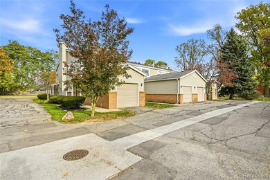 View of front of home featuring brick siding, driveway, and a chimney
