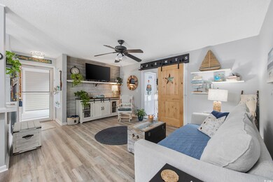 Living room with a textured ceiling, light wood-ty