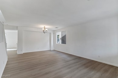 Unfurnished room with light wood-style floors and a chandelier