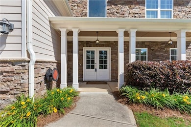 Property entrance featuring covered porch and stone siding