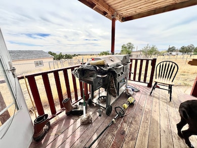 Wooden terrace with area for grilling and a fenced backyard
