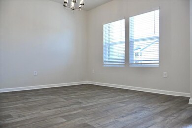 Empty room with a chandelier and dark wood-style floors