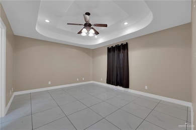 Unfurnished room with ceiling fan, baseboards, a raised ceiling, recessed lighting, and light tile patterned flooring