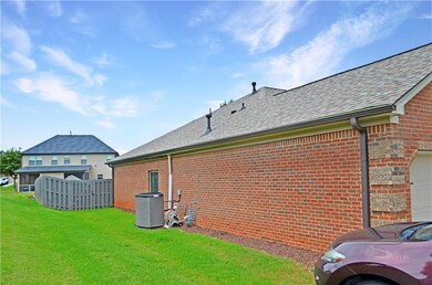 View of property exterior featuring cooling unit, roof with shingles, and brick siding