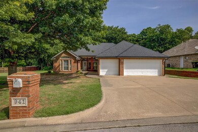 Ranch-style home with a garage, brick siding, driveway, and a front lawn