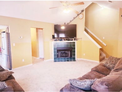 Living room with a tile fireplace, light carpet, a