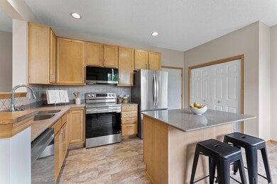 The kitchen features stainless steel appliances,  stylish tile backsplash,  large pantry closet, and a center island with seating. Conveniently located off the kitchen is the attached 2-car garage.