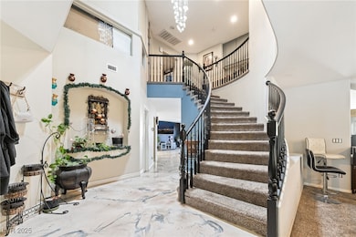 Staircase with a towering ceiling, recessed lighting, and a chandelier