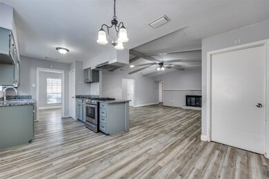 Kitchen with gray cabinetry, island range hood, li